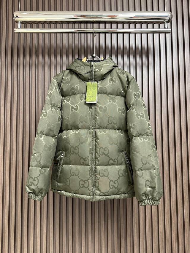 Gucci 满印双g Logo面包羽绒服，采用科技防风水帆布材 质打造，高标90％鸭绒填充，满幅经典互扣式双g字母 菱形链条暗纹提花设计，情侣款复古美学连帽羽绒