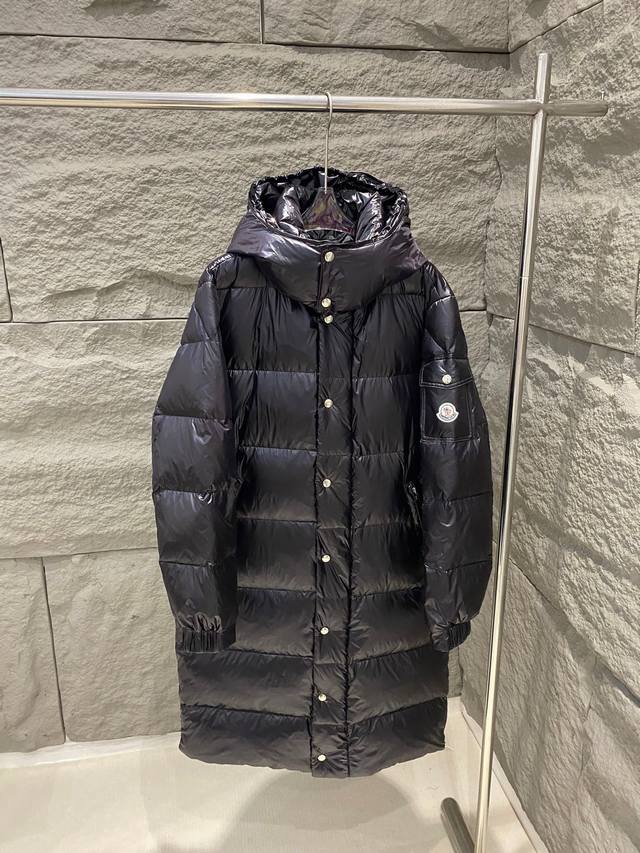 Moncler Hanoverian长款连帽羽绒服外套 Hanoverian长款羽绒夹克采用nylon Laqué面料制成，搭配实用细节设计，保暖与防护兼备。搭